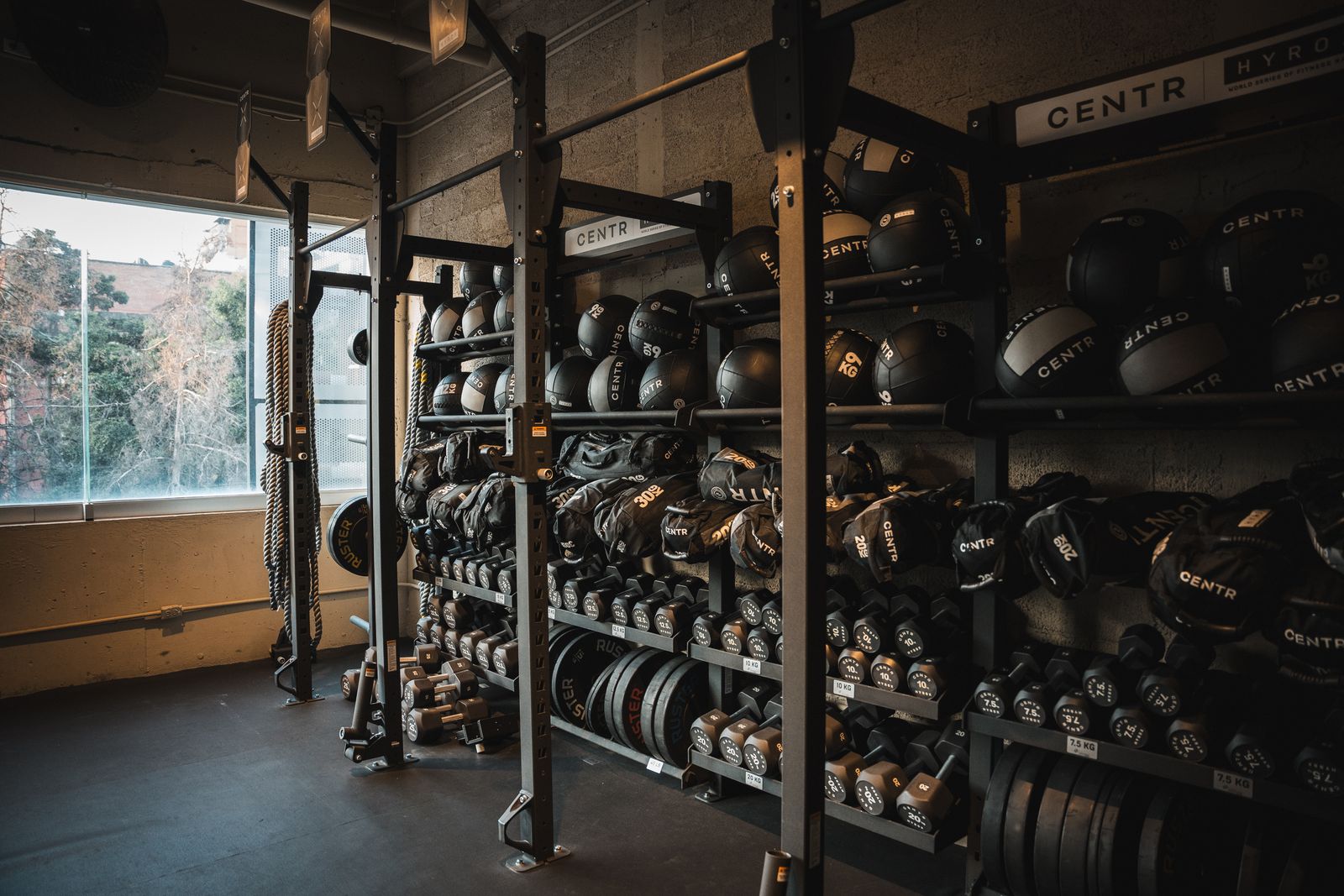Rig de almacenamiento con wall balls, sandbags, kettlebells y discos CENTR x HYROX en el HYROX Performance Center