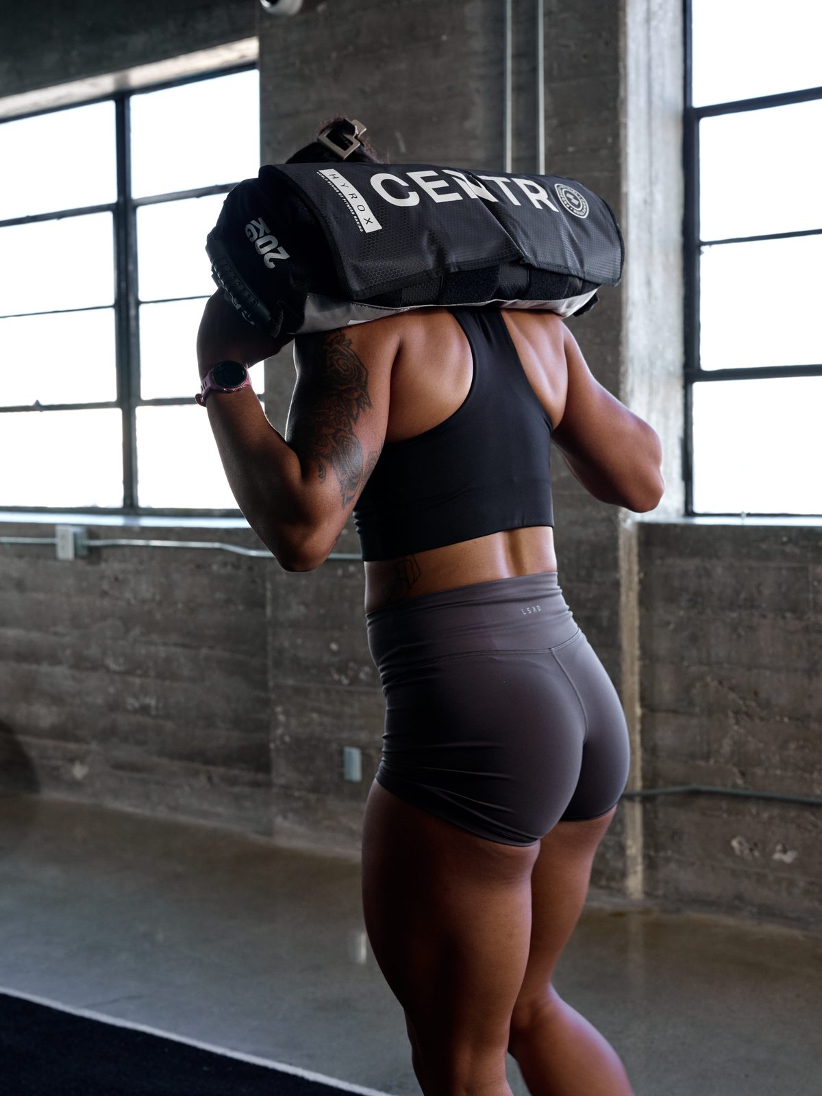 Atleta cargando un Sandbag CENTR x HYROX al hombro